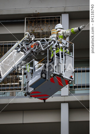 A firefighter who stretches a ladder and conducts rescue operation training in a basket 84138740