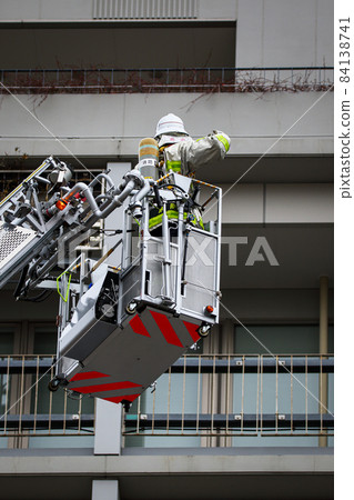 A firefighter who stretches a ladder and conducts rescue operation training in a basket 84138741