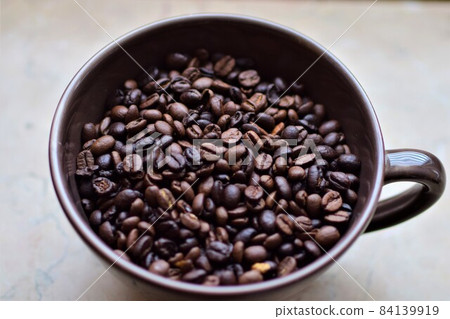 Roasted coffee beans in a cup as a close up 84139919