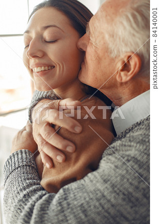 Elegant old man standing at home with his granddaughter 84140001