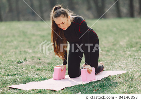 Cute girl doing yoga in a summer park Cute girl doing yoga in a summer park 84140858