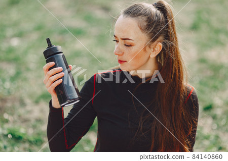 Cute girl doing yoga in a summer park Cute girl doing yoga in a summer park 84140860