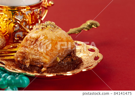 Turkish baklava and coffee in oriental dishware on red background 84141475