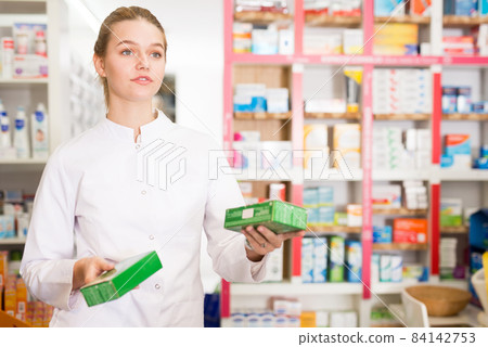 Young friendly female pharmacist suggesting useful tablets in pharmacy Young friendly female pharmacist suggesting useful tablets in pharmacy 84142753