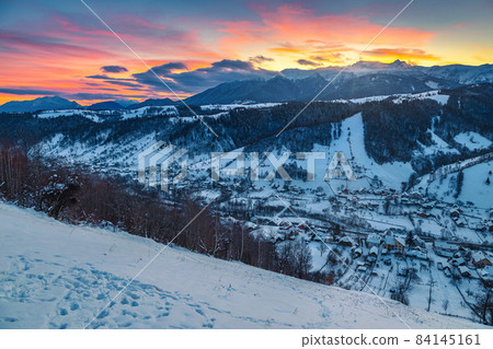 Stunning winter landscape with snowy slopes at sunrise, Carpathians, Romania Stunning winter landscape with snowy slopes at sunrise, Carpathians, Romania 84145161