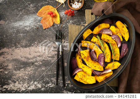 Pumpkins slice with rosemary and purple onion, baking fresh healthy food with spice on a dark stone background. Keto or paleo diet veggie vegan or vegetarian. Top view flat lay background. Copy space. Pumpkins slice with rosemary and purple onion, baking fresh healthy food with spice on a dark stone background. Keto or paleo diet veggie vegan or vegetarian. Top view flat lay background. Copy space. 84145281