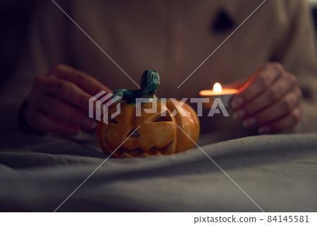 Female preparing ceramic jack o lantern for Halloween celebration 84145581