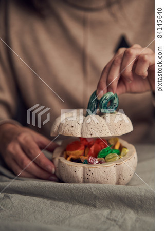 Anonymous female opening container with sweets 84145640