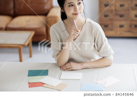 Young woman writing a letter by the window 84145646