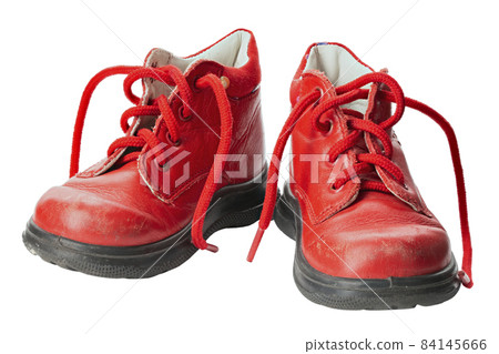 Children's shoes of red color isolated on white background. Old shoes. Children's shoes of red color isolated on white background. Old shoes. 84145666