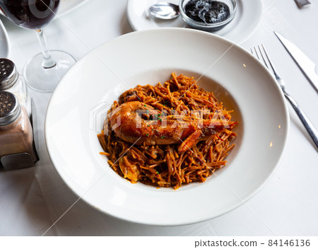Seafood fideua with shrimps served with black garlic aioli 84146136