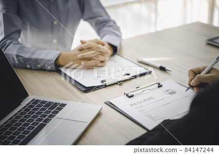 Human resource manager Is explaining the job to the job seeker before filling out a resume on the application form to consider accepting for employment in the company.. 84147244