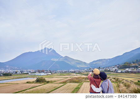 A young woman and a friend shooting Mt. Yufu on a girls' trip 84147380