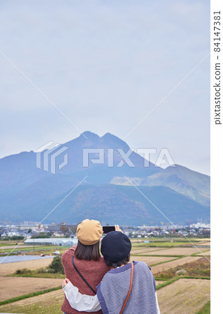 A young woman and a friend shooting Mt. Yufu on a girls' trip 84147381