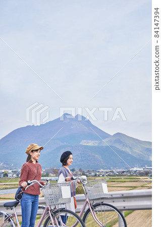 Young women and friends walking around Yufuin by bicycle 84147394
