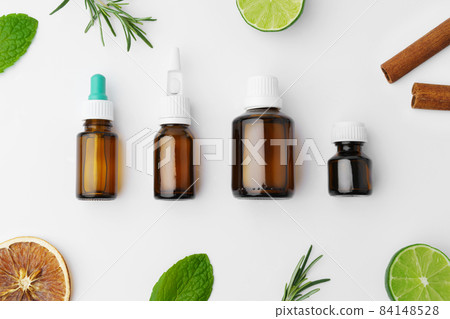 Essential oil bottles and citrus fruit on white background 84148528