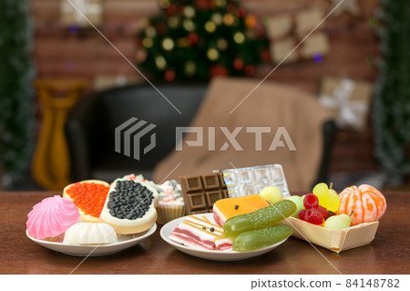 Handmade soap in the form of natural food fruits, berries, chocolate, sandwiches with caviar, bacon, cucumbers, sweets on the background of a Christmas tree Handmade soap in the form of natural food fruits, berries, chocolate, sandwiches with caviar, bacon, cucumbers, sweets on the background of a Christmas tree 84148782