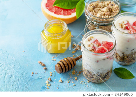Vegan healthy breakfast. Granola with greek yogurt, honey and grapefruit in a glass. Copy space. Vegan healthy breakfast. Granola with greek yogurt, honey and grapefruit in a glass. Copy space. 84149060