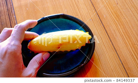 Photo of holding a sweet potato in hand 84149337