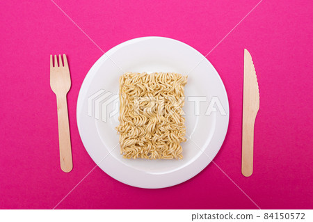 Uncooked Instant Noodles on White Plate Uncooked Instant Noodles on White Plate 84150572