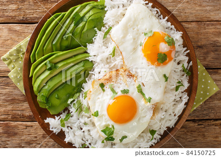 Latin American food of boiled rice and fried eggs close-up in a plate. horizontal top view Latin American food of boiled rice and fried eggs close-up in a plate. horizontal top view 84150725