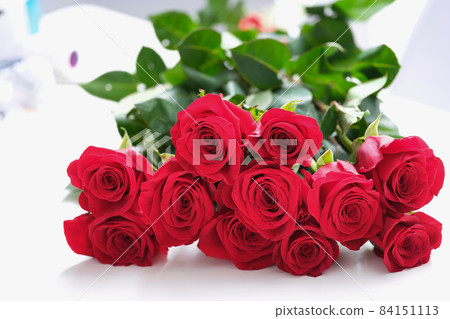 A large bouquet of red roses lies on the table 84151113