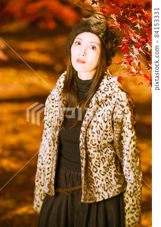 A cute girl under a maple branch at a high angle A cute girl under a maple branch at a high angle 84153331