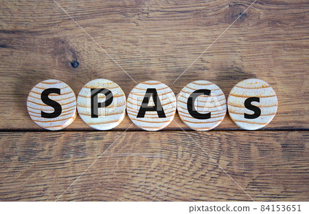 SPACs symbol. Wooden circles with words 'SPACs, special purpose acquisition companies' on beautiful wooden background, copy space. Business and SPACs concept. 84153651