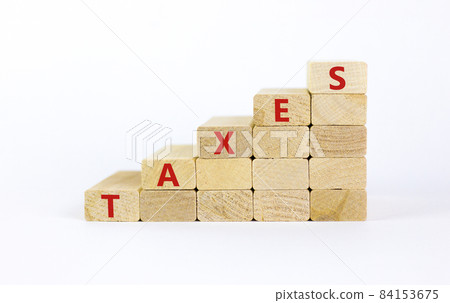 Taxes symbol. Concept word 'taxes' on wooden cubes on a beautiful white table. White background. Business and taxes concept. Copy space. 84153675