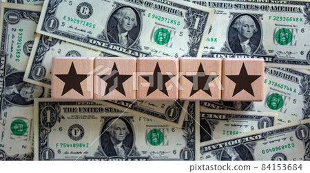 Wood cubes with star sign on dollar bills, copy space. Quality and luxury conceptual image. Wood cubes with star sign on dollar bills, copy space. Quality and luxury conceptual image. 84153684