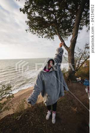 Young woman on cold autumn seashore posing at camera 84154052
