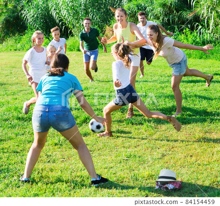 Parents with children gaily spending time together playing with ball outdoors 84154459