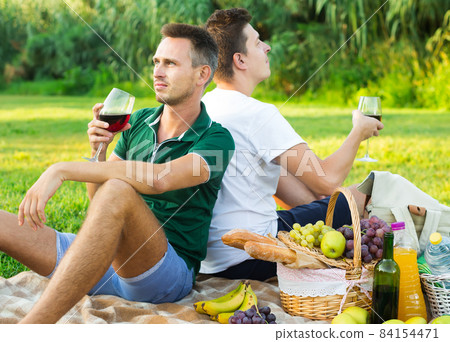 adult man with a friend enjoying picnic adult man with a friend enjoying picnic 84154471