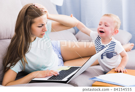 Perplexed mom is having issue with work while kid crying 84154555
