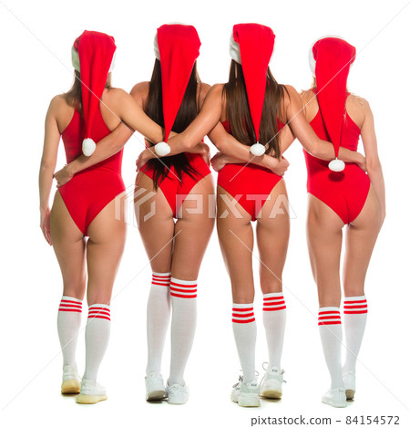 Christmas. Full length back view of sporty long legged christmas girls in Santa Claus hats and red swimsuits standing close isolated on white background Christmas. Full length back view of sporty long legged christmas girls in Santa Claus hats and red swimsuits standing close isolated on white background 84154572