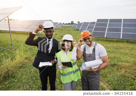 Two inspectors and foreman smiling on camera at solar farm 84155418