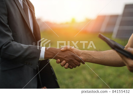 Technician and businessman shaking hands on solar plant 84155432