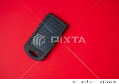 clean energy solar battery powerbank top view on red background clean energy solar battery powerbank top view on red background 84155910