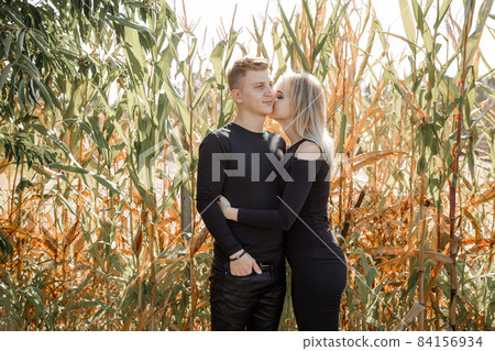 Man and woman are near the corn. Love and happiness concept. Couple in field. Autumn time. 84156934