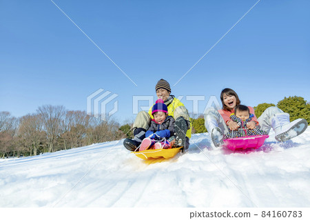 一家四口在雪地公園玩耍 84160783