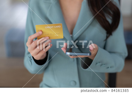 Close up woman in a cafe shopping online with credit card and mobile phone Close up woman in a cafe shopping online with credit card and mobile phone 84161385