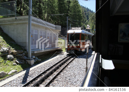 Gornergrat mountain railway, Findelbach station, passing by the train coming down from Gornergrat Gornergrat mountain railway, Findelbach station, passing by the train coming down from Gornergrat 84161536