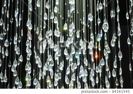 Crystal stones dangle and glisten on black background. Shining crystal chandelier. 84161545