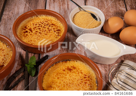 Chef cooks creme brulee with gas burner, dessert in the home kitchen, Cooking at home, professionals Chef cooks creme brulee with gas burner, dessert in the home kitchen, Cooking at home, professionals 84161686