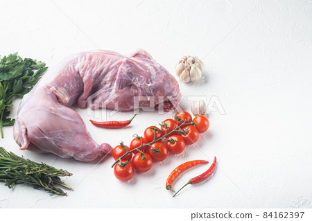 Fresh whole rabbit meat with with lemon, salt and parsley, on white stone background, with copy space for text Fresh whole rabbit meat with with lemon, salt and parsley, on white stone background, with copy space for text 84162397