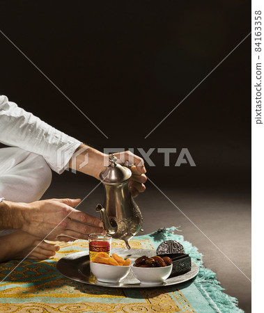 man white pouring tea tiny cup front view. High quality beautiful photo concept man white pouring tea tiny cup front view. High quality beautiful photo concept 84163358