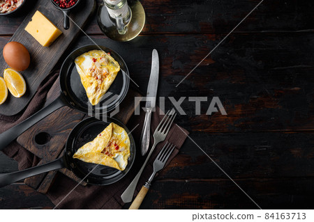 Fried breakfast omelette with crab meat and cheese, on frying iron pan, on dark wooden background, top view flat lay , with copyspace and space for text 84163713