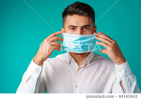 Handsome mixed-race man wearing medical face mask Handsome mixed-race man wearing medical face mask 84165602