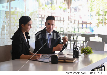 Businessman negotiating about business project with his business partner in modern workplace. Businessman negotiating about business project with his business partner in modern workplace. 84167169