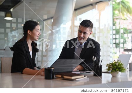 Businesswoman discussing project planning with her colleague at modern office. Businesswoman discussing project planning with her colleague at modern office. 84167171